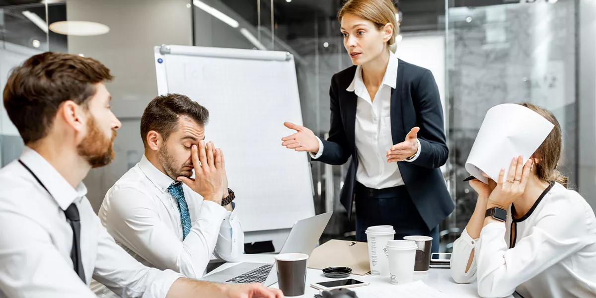 weibliche Managerin oder Teamleiterin, die während einer Konferenz im Besprechungsraum mit den Mitarbeitern diskutiert