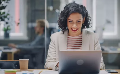 Frau sitzt im Büro vor einem Laptop