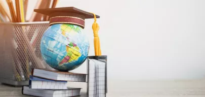 Graduiertenhut auf Globus, Bücher mit Bleistiften auf Holz weißem Hintergrund.
