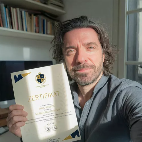 Mann in dunklem Hemd und dunklen lockigen Haaren