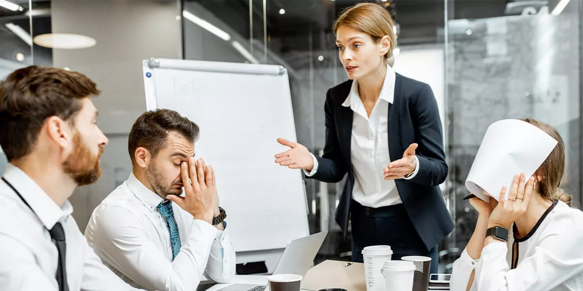 weibliche Managerin oder Teamleiterin, die während einer Konferenz im Besprechungsraum mit den Mitarbeitern diskutiert