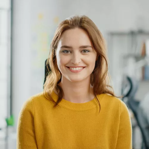 Frau mit braunen Haaren in gelbem Strickpullover