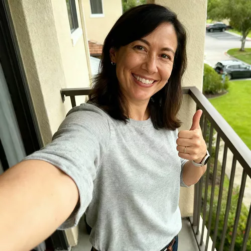 Frau mit langen, brauen, lockigen Haaren und Sommersprossen