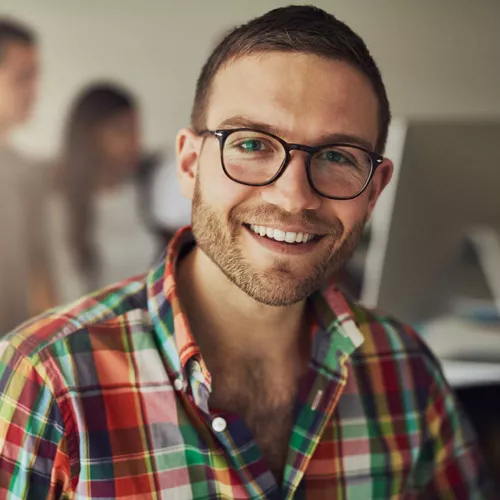 Mann in buntem Hemd mit Brille und brauen kurzen Haaren