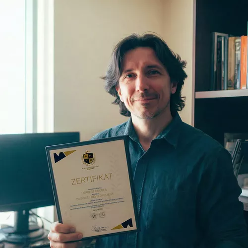 Mann im Hemd mit Brille und grau-schwarzen Haaren