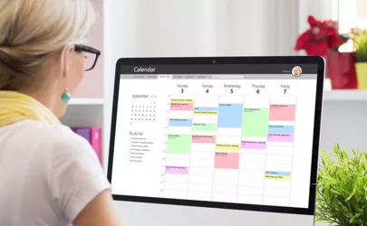Frau verwendet Kalender-App auf Computer im Büro