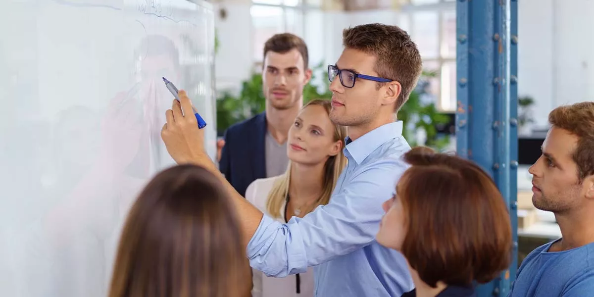 Mitarbeiter arbeiten zusammen an einem Projekt auf einem Flipchart