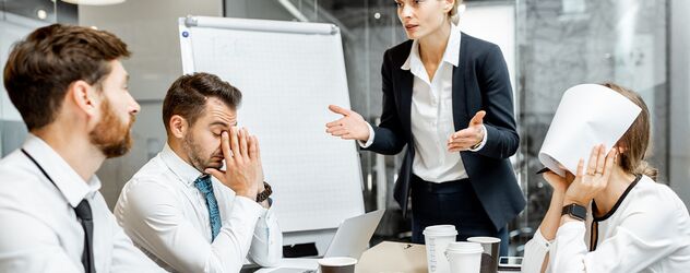 weibliche Managerin oder Teamleiterin, die während einer Konferenz im Besprechungsraum mit den Mitarbeitern diskutiert