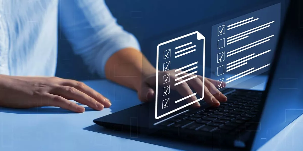 ein Mann arbeitet an seinem Laptop mit Checkliste und Zwischenablage