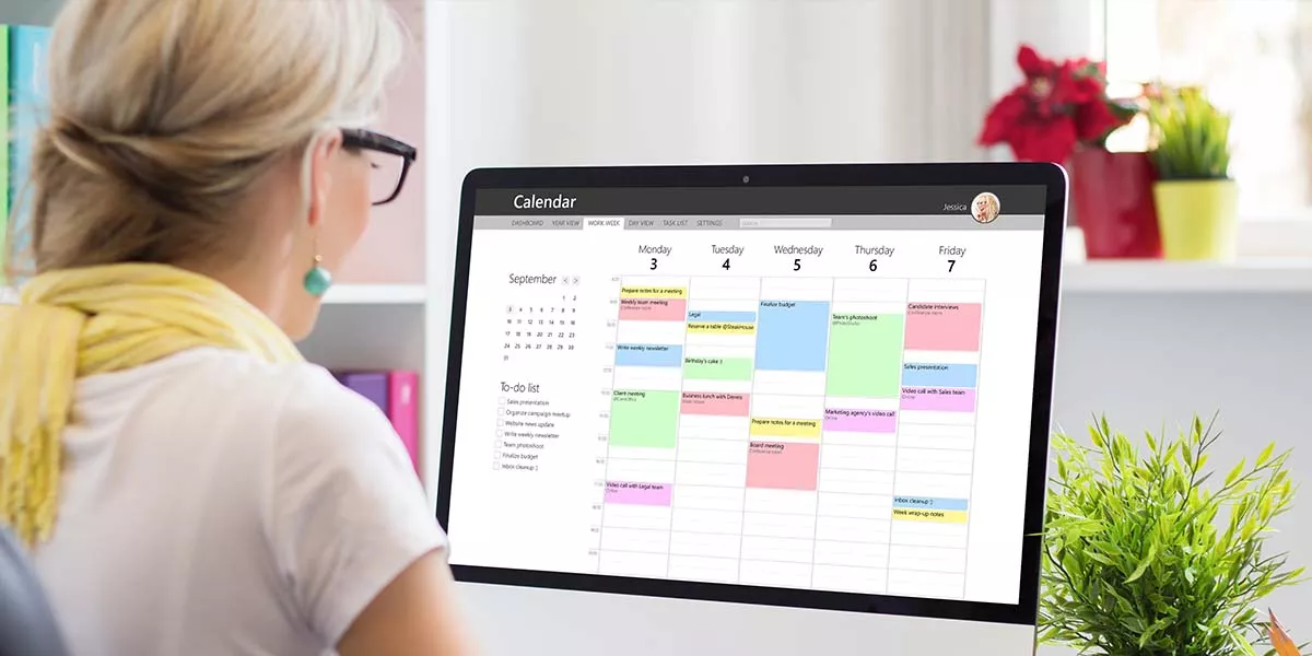 Frau verwendet Kalender-App auf Computer im Büro