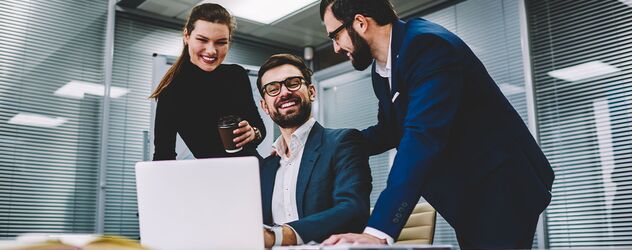 Kollegen, die lachen und gemeinsam über ein erfolgreiches Meeting-Projekt diskutieren